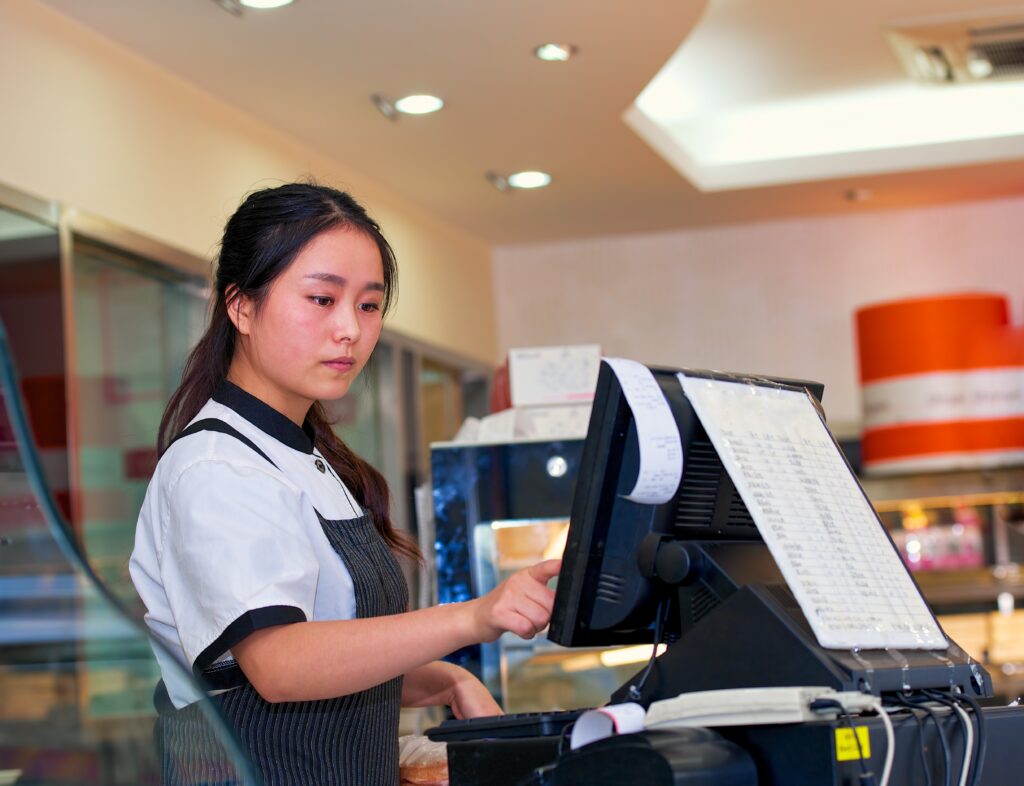 A young teen working the cash register at her summer job. 