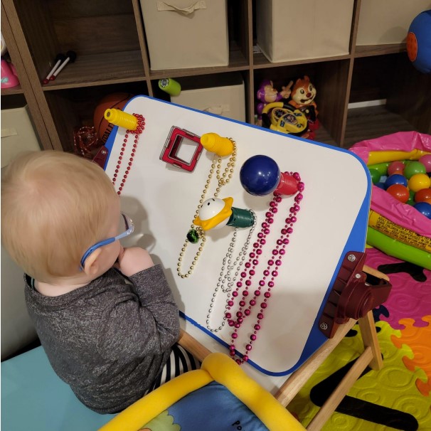 Dominic is sitting on the wedge and playing with the magnet part of the APH All-In-One board.